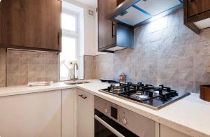 a kitchen with a stove and a counter top at Cozy 1 bedroom apartment in Notting Hill in London