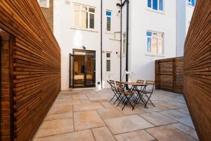 a courtyard with a wooden fence and a table and chairs at Cozy 1 bedroom apartment in Notting Hill in London