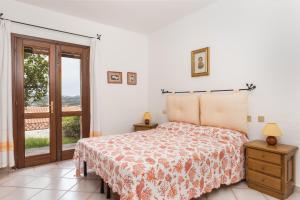 a white bedroom with a bed and a balcony at Trilocale Portovenere Baia II in Cannigione
