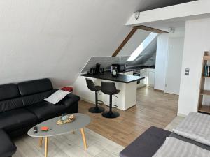 a living room with a black couch and a table at Appartement Sonnenschein in Hüllhorst