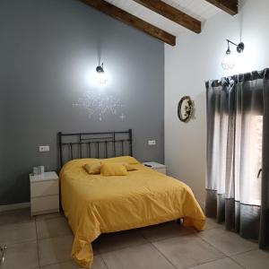 1 dormitorio con 1 cama con colcha amarilla en Casa Huidobro Valle, 