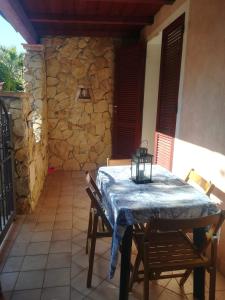 una mesa y sillas en un patio con una pared de piedra en Casa Azzurra, en Capitana
