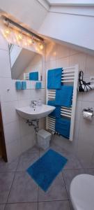 W łazience znajduje się umywalka, lustro i niebieskie ręczniki. w obiekcie Haus Bergblick w mieście Mittenwald