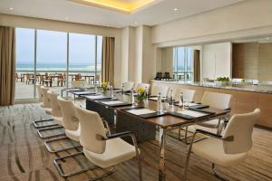 uma sala de conferências com uma mesa longa e cadeiras brancas em DoubleTree by Hilton Dubai Jumeirah Beach em Dubai