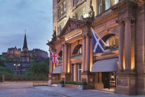 エディンバラにあるThe Caledonian Edinburgh, Curio Collection by Hiltonの旗の横に二本の建物