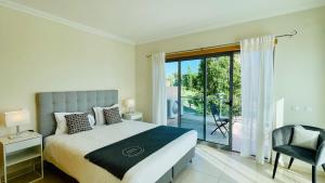 a bedroom with a bed and a sliding glass door at Branca by Check-in Portugal in Albufeira