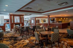 a hotel lobby with tables and chairs and a bar at Hilton Garden Inn Erie in Erie