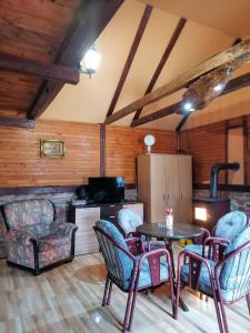 Vikendica na Drini DRINSKI ODMOR في Crnča: غرفة معيشة مع طاولة وكراسي