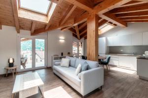 Una sala de estar con un sofá y una cocina. en Serendipity- by MyHomeInComo, en Lenno