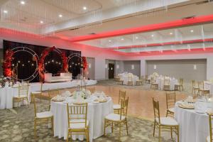 - une salle de banquet avec des tables et des chaises blanches dans l'établissement Hilton Hasbrouck Heights-Meadowlands, à Hasbrouck Heights