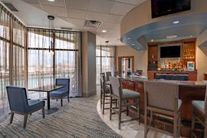 a bar in a hotel room with chairs and a counter at DoubleTree by Hilton New Bern - Riverfront in New Bern