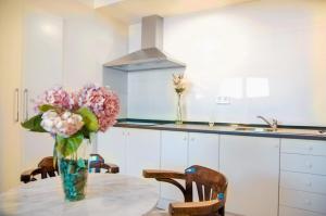 ガラパガルにあるApartamentos individuales con piscinaの花瓶のテーブル付きキッチン
