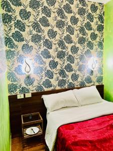 1 dormitorio con cama y pared con papel pintado en Magenta Roma house en Roma