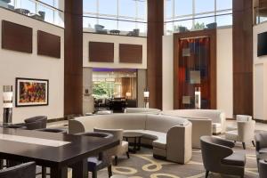 a lobby with tables and chairs in a building at Hilton Meadowlands in East Rutherford