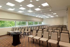 ein leeres Zimmer mit Stühlen, Tischen und Fenstern in der Unterkunft Hilton Meadowlands in East Rutherford