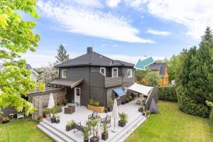 a house with a backyard with a patio at 2 Bedroom apartment w/ Parking & Balcony in Tønsberg