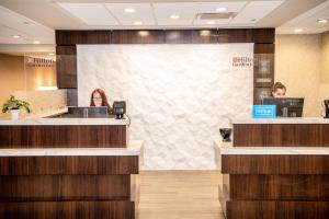 two women sitting at a counter in a hotel lobby at Hilton Garden Inn Fayetteville/Fort Bragg in Fayetteville