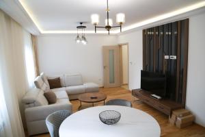 uma sala de estar com um sofá e uma mesa em Lakeside Serenity em Žabljak