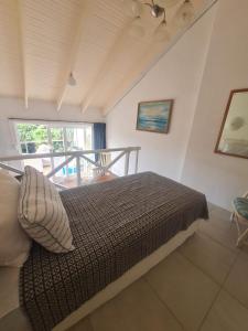 1 dormitorio con 1 cama y balcón en Ocean Walk Marlin, en Zinkwazi Beach
