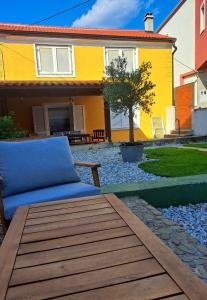 a couch sitting on a wooden deck in front of a house at Kvarner holiday home in Jadranovo