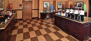 um bar com garrafas de vinho num piso xadrez em Hampton Inn & Suites Fredericksburg em Fredericksburg