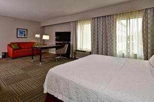 a hotel room with a large bed and a desk at Hampton Inn & Suites Fredericksburg in Fredericksburg +22 photos