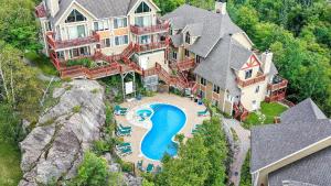 an aerial view of a large house with a swimming pool at Ski Inout 2brs On The Mountain! 197-3 in Mont-Tremblant
