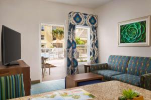 a living room with a couch and a television at Homewood Suites by Hilton Fort Myers in Fort Myers