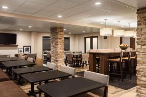 a restaurant with tables and chairs and a bar at Hampton Inn by Hilton Fort Smith in Fort Smith