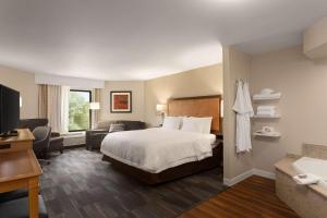 史密斯堡Hampton Inn by Hilton Fort Smith的一间带床和客厅的酒店房间