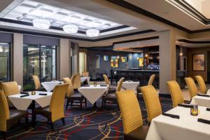 un restaurant avec des tables et des chaises et un bar dans l'établissement Hilton Garden Inn Ft Worth Alliance Airport, à Roanoke