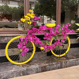 a yellow bicycle with flowers on it sitting on some steps at Saint George Hotel in Loutra Edipsou
