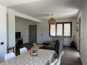 een woonkamer met een tafel en een bank bij La dimora delle Rose in Passignano sul Trasimeno