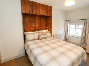 a bedroom with a large bed with a wooden headboard at Tawny Owl in Carnforth