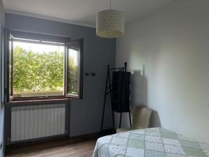 1 dormitorio con cama, ventana y silla en La dimora delle Rose, en Passignano sul Trasimeno