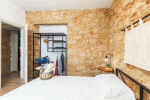 una camera da letto con un muro in pietra e un letto di Dommu Anna a Baunei
