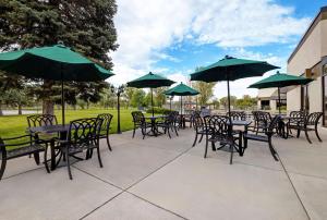 a group of tables and chairs with green umbrellas at DoubleTree by Hilton Grand Junction in Grand Junction