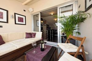 a living room with a couch and a table with wine glasses at Apartments Villa Markiz in Rovinj