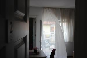 a room with a window with a white curtain and a table at Pansion Infinity in Mostar