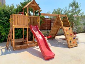 a wooden play set with a slide and a climbing frame at Olive Garden in Posedarje