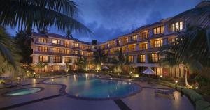 un hotel con piscina frente a un edificio en DoubleTree by Hilton Hotel Goa - Arpora - Baga, en Baga