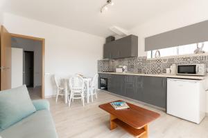 a kitchen and living room with a couch and a table at Quinta dos Passarinhos in Nadadouro