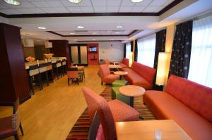 a waiting room with couches and tables and a bar at Hampton Inn Groton/Mystic in Groton