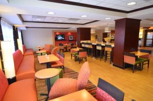 a restaurant with tables and chairs and a bar at Hampton Inn Groton/Mystic in Groton