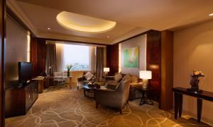 a living room with a couch and a television at DoubleTree by Hilton Qinghai - Golmud in Golmud