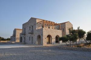 an old brick building with scaffolding on it at Terra Di Pietra Exclusive Suites & Apartments in Areopolis