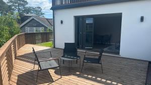 a deck with two chairs and a table and chairs at Moderne Leilighet med panorama utsikt check -In 24 h in Sandefjord +9 photos