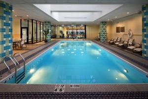 哈特福德的住宿－Hilton Hartford，酒店大堂的大型室内游泳池,有蓝色的水