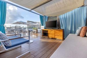 uma sala de estar com televisão numa varanda em Hilton Grand Vacations Club Hokulani Waikiki Honolulu em Honolulu
