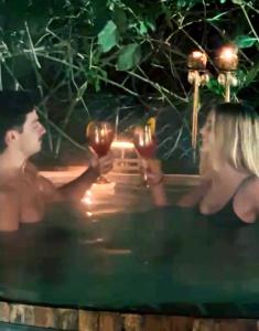 a man and a woman holding wine glasses in a pool at La Casita- imawi in Belén de Escobar